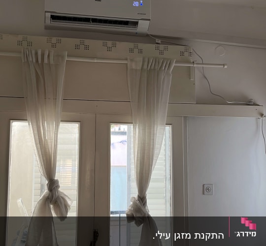 מזגן מותקן על קיר עם תצוגת טמפרטורה